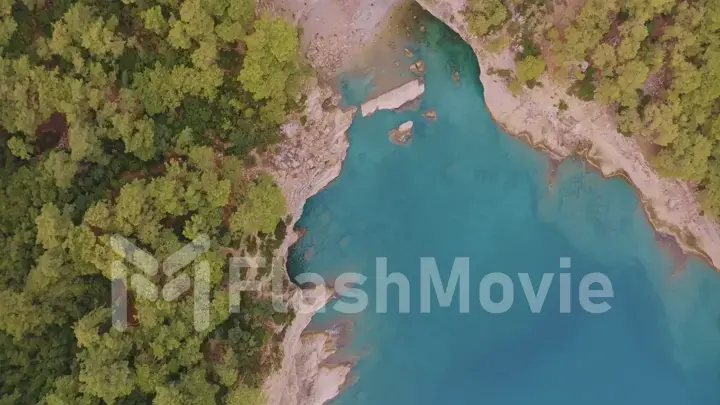 Beautiful seascape. Green trees on the coastline. Rocky coast. Blue water. View from above