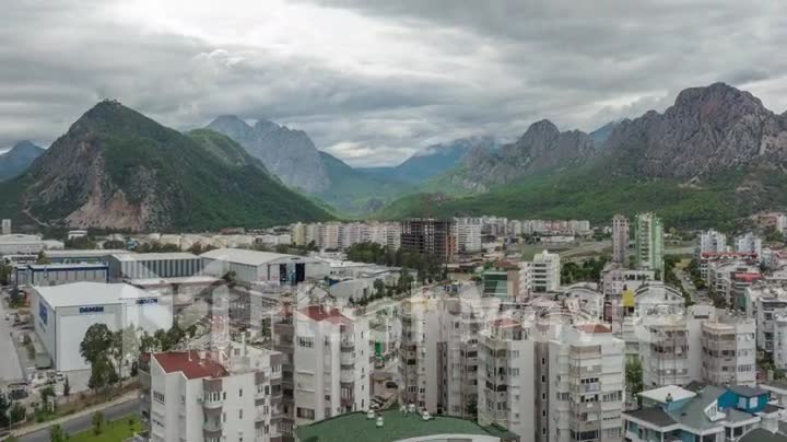 Beautiful cityscape against the backdrop of mountains. Human and nature. Top view. Multi-level intersection. Timelapse