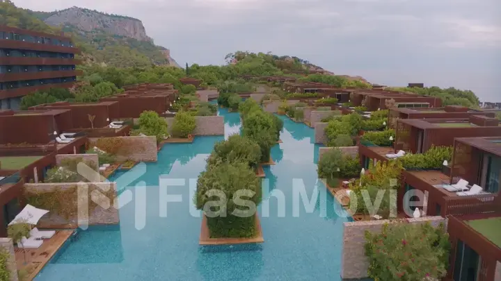Aerial drone view of the hotel courtyard. Vacation at the resort. Green shrubs. Mountains in the background