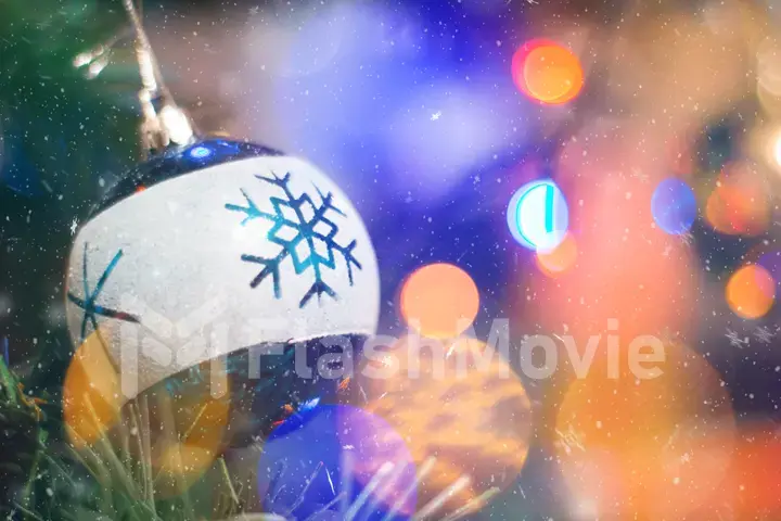 Christmas ball on a branch of spruce with blurred lights garland bokeh on New Year's Eve. Christmas background