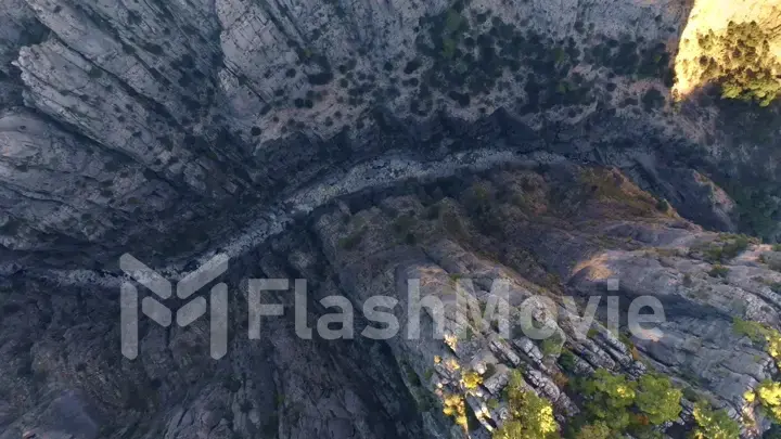 Aerial drone view of dry mountain river. Stone gorge. Green plants on the rocks. Beautiful landscape.