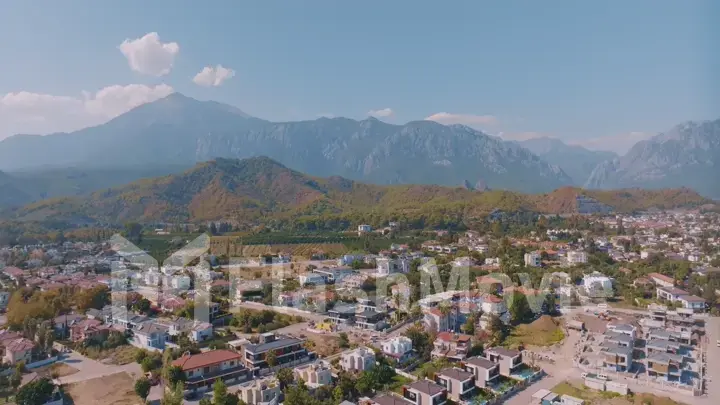 Aerial panorama of small resort town. Hotels, houses and roads. Green hills around. Mountain landscape. Photography