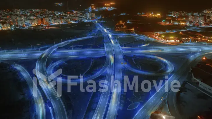 Aerial drone photography multi-level intersection. Neon blue night lighting. Cars. City illumination. Road architecture