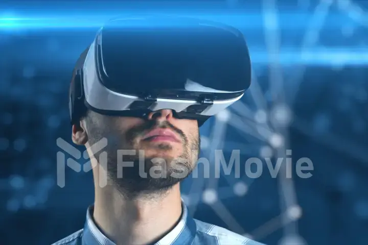 A young man with a beard in glasses of virtual reality on a technological background