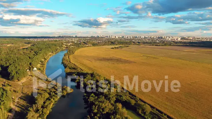 Flight in the beautiful countryside among a river of woods and fields near the city