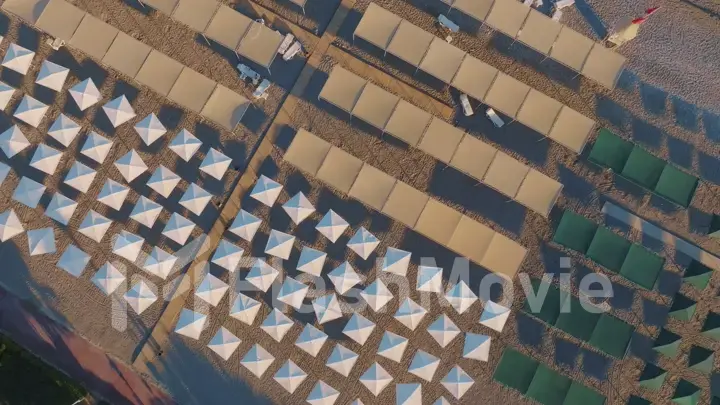 Top view of beach chairs, sand, beach umbrellas, coastline. Vacation.