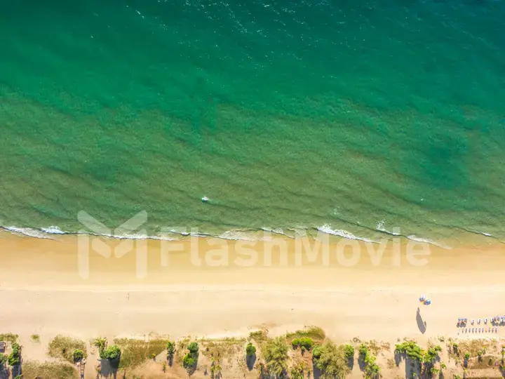 Top view on sandy beach and emerald ocean water. Aerial photography