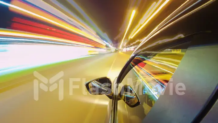 Driving a car in the city at night. The camera on the hood of the car. Hyperlapse in the evening in the center of the city on the highway. Abstract soft glowing lines.