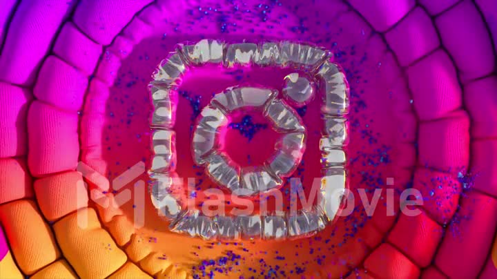 The inflatable Instagram logo emerges from a smooth pink purple orange surface. Top view. Transformation. Social media.