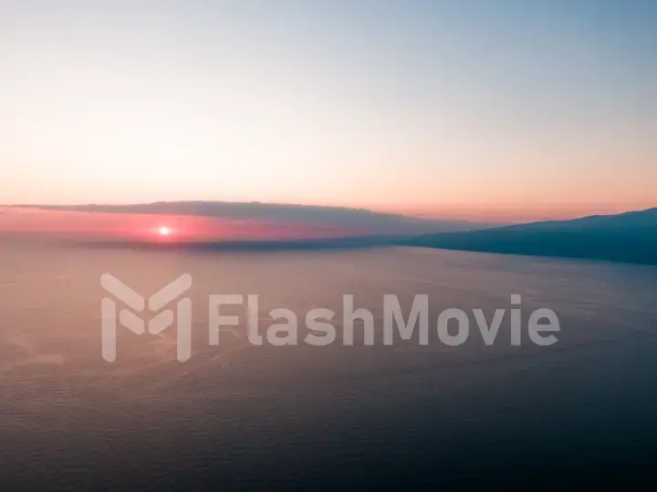 Aerial photo from flying drone of a fascinating nature landscape with dramatic evening sunset sky which reflected in sea water with calm waves. Beautiful scenery of a Indian Ocean with sunrise