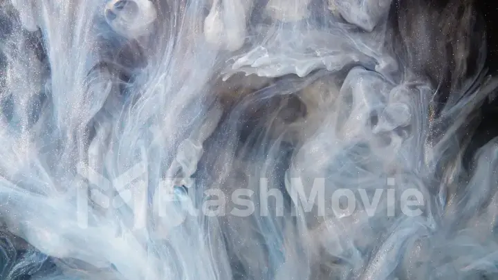 Abstract bronze paint mixed with different multi-colored paints in water in slow motion. Inky cloud swirling flowing underwater. Abstract smoke explosion