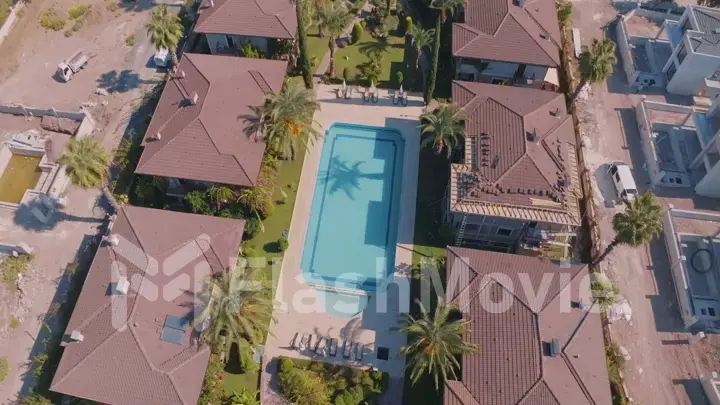 Aerial drone view of the hotel territory. Top view. Swimming pool, palm trees, sun loungers. Holidays at the resort