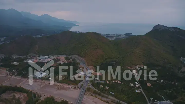 Landscape at sunset. Aerial drone view of the resort town. Clouds. Mountains in the background