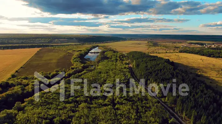 Flight in the beautiful countryside among a river of woods and fields near the city