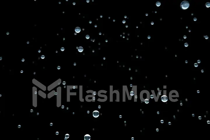 Frozen drops of water in the space on a black isolated background, of the flight of the camera