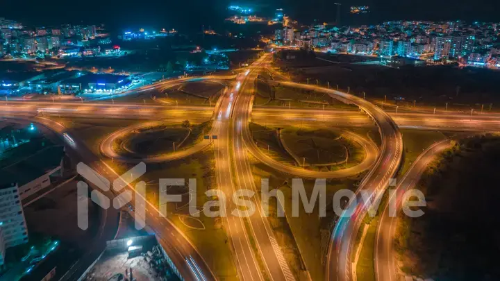 Aerial drone photography multi-level intersection. Additional movement. Cars. Neon yellow blue. Night illumination