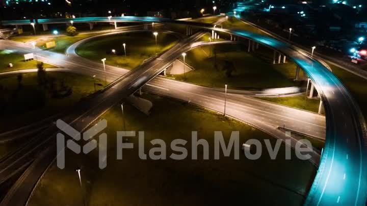 Hyperlapse timelapse of night city traffic on stop street intersection circle roundabout in megalopolis. 4K UHD aerial view.