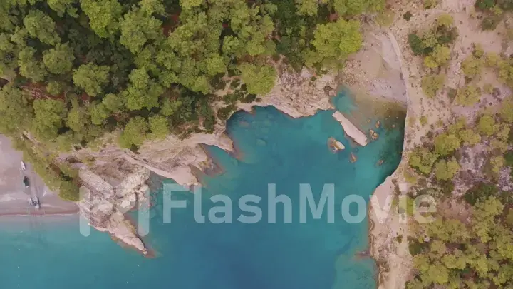 Beautiful seascape. Green trees on the coastline. Rocky coast. Blue water. View from above