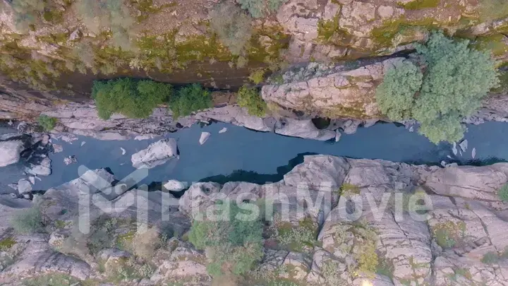 Top view of the mountain river. Rocky shores. Aerial drone view. Green trees and shrubs on the rocks