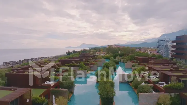 Aerial drone view of the hotel courtyard. Vacation at the resort. Green shrubs. Mountains in the background