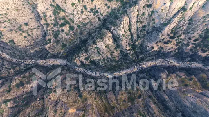 Aerial drone view of dry mountain river. Stone gorge. Green plants on the rocks. Beautiful landscape.