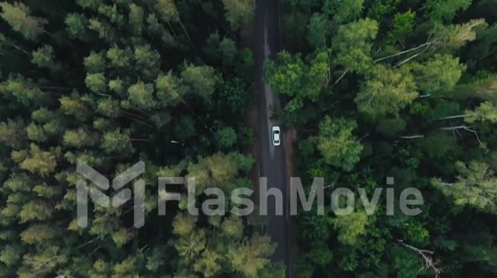 Aerial top down 4k view of white car driving