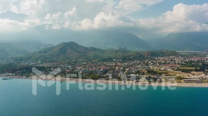 View from the sea to the coastal city. Sunny day. Green mountains. Drone video 4k footage. Landscape. Coastline. Boats.