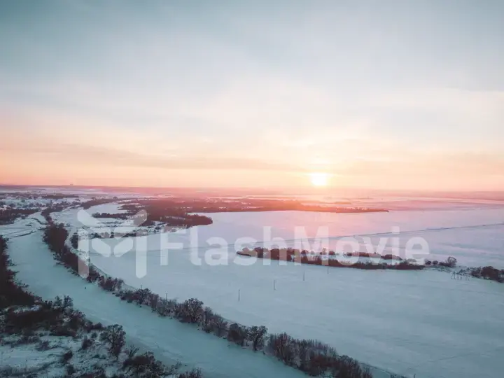 The Aerial view of snow-covered forest in time of sunny winter evening.