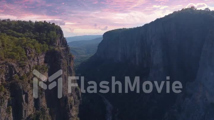 Flight over the green canyon at sunset. Magic view. Natural landscape. Aerial drone footage. Green trees and river