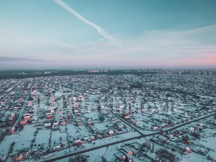 The Aerial view of snow-covered forest in time of sunny winter evening.