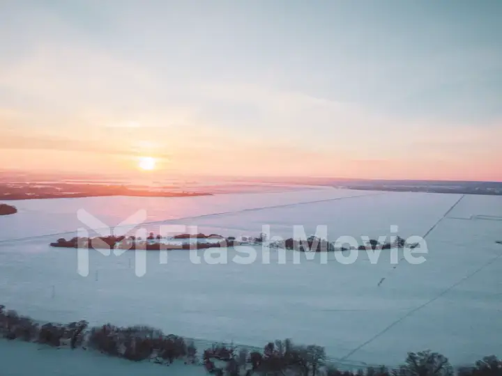 The Aerial view of snow-covered forest in time of sunny winter evening.