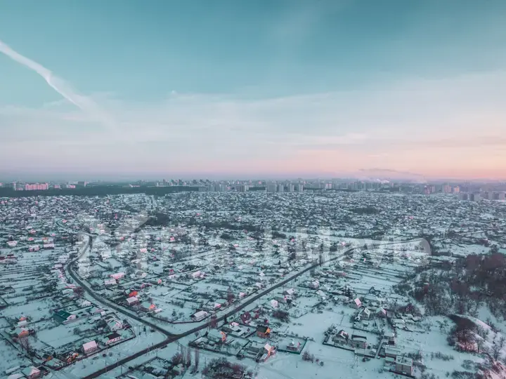 The Aerial view of snow-covered forest in time of sunny winter evening.