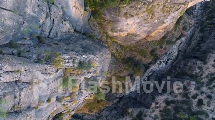 Top view of the mountain river. Rocky shores. Drone video footage. Green shrubs on the rocks. Fall from a cliff
