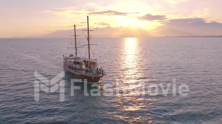 Vintage sailing ship sails on the sea at sunset. Seascape. Calm water. Top view. Aerial video footage from a drone.