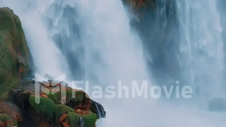 Waterfall from a cliff close-up. Aerial drone view. A stormy stream of water falls down. Nature background