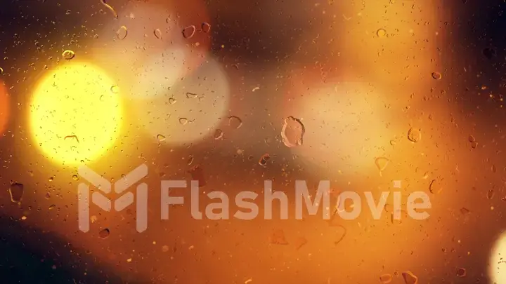 Drops of rain flow down the glass against the bokeh background of moving cars