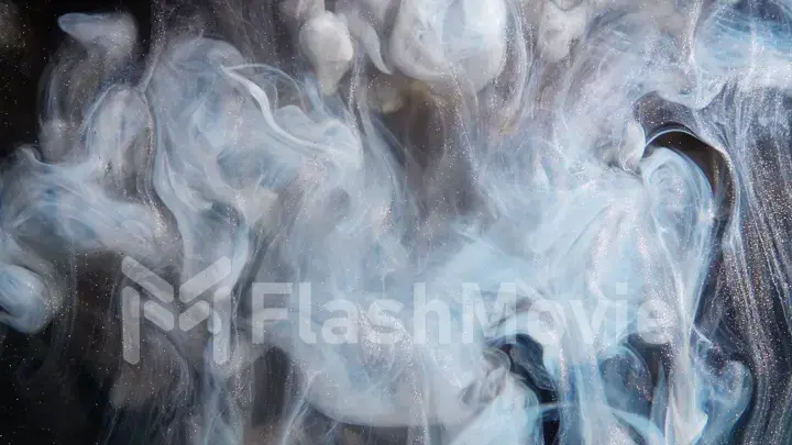 Abstract bronze paint mixed with different multi-colored paints in water in slow motion. Inky cloud swirling flowing underwater. Abstract smoke explosion