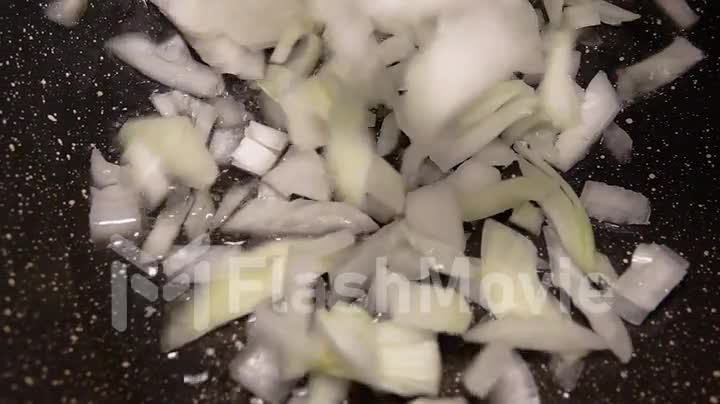 Close-up onion frying in a pan in oil in slow motion