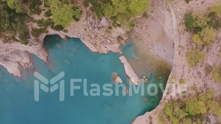 Beautiful seascape. Green trees on the coastline. Rocky coast. Blue water. View from above