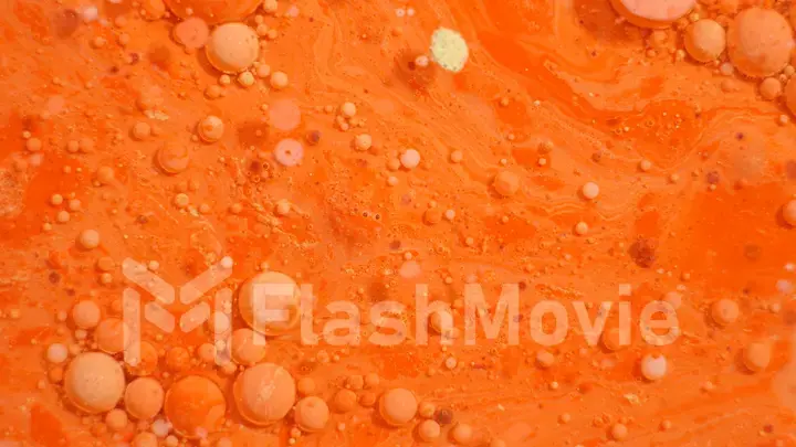 Bright colorful orange bubbles on the surface of the water. Abstract paint bubbles