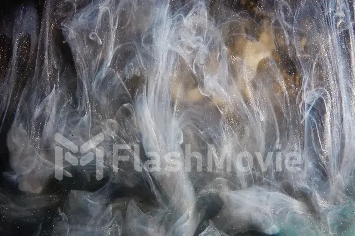 Abstract bronze paint mixed with different multi-colored paints in water in slow motion. Inky cloud swirling flowing underwater. Abstract smoke explosion