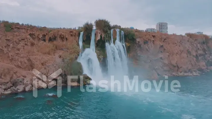 The concept of nature and man. Blue Lagoon Stormy waterfall. Rocky coast. The hotel is in the background.