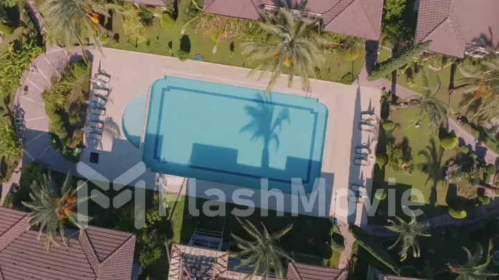 Aerial drone view of the hotel territory. Top view. Swimming pool, palm trees, sun loungers. Holidays at the resort