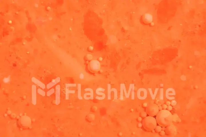 Bright colorful orange bubbles on the surface of the water. Abstract paint bubbles