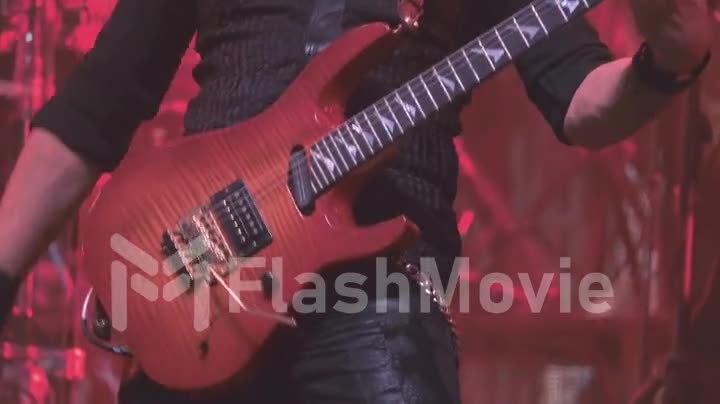 A virtuoso guitarist playing an electric guitar on stage with flashing LED lights.