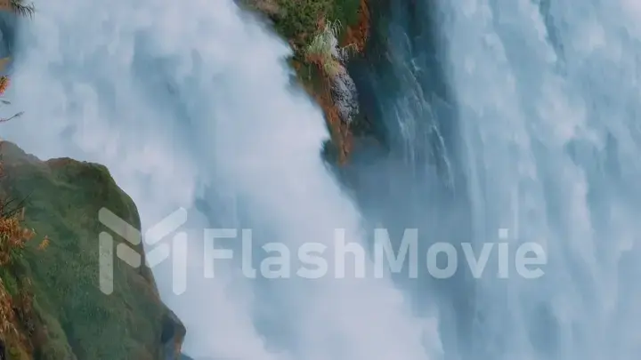 Waterfall from a cliff close-up. Aerial drone view. A stormy stream of water falls down. Nature background