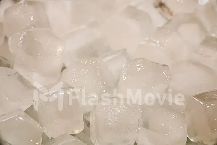 Macro shot of ice cubes from clear water that melt in slow motion on a white background. Concept: pure mountain spring water, ice, cocktails, fresh and frozen foods.