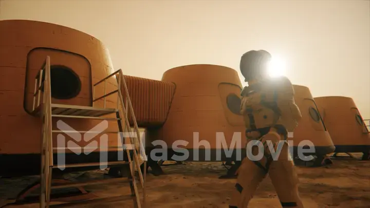 Astronaut on the planet Mars, making a detour around his base. Astronaut walking along the base. Small dust storm. The satellite dish sends data to the ground. Realistic 3D illustration