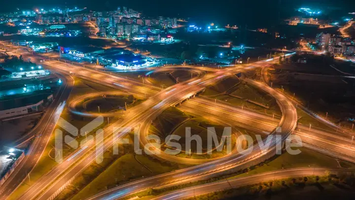 Aerial drone view multi-level intersection. Neon blue night lighting. Cars. City illumination. Road architecture