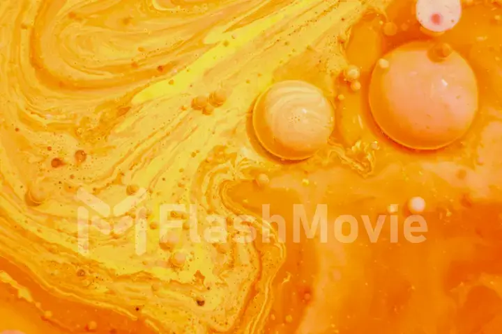 Bright colorful orange bubbles on the surface of the water. Abstract paint bubbles